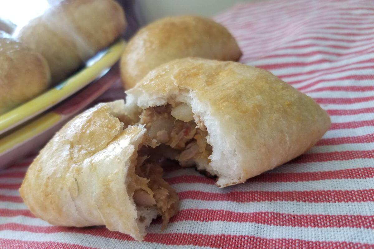 Recipe blog post featuring a close-up image of a Sri Lankans fish buns split in half to display the filing inside.