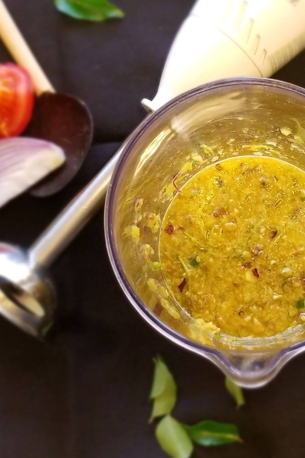 Overhead view of rasam in a bowl with visible herbs and spices.  
