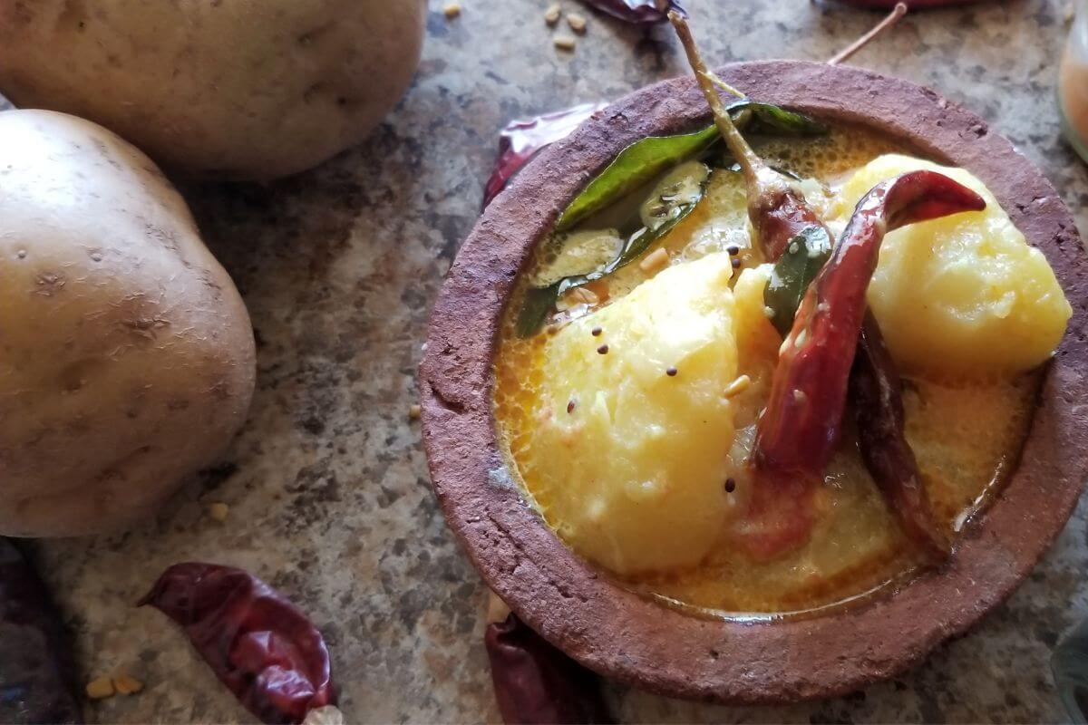 Overhead view of Sri Lankan potato curry in a clay pot.