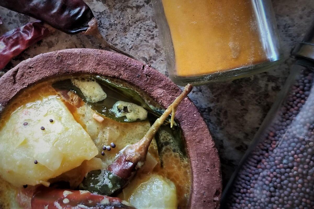Sri Lankan potato curry served in a clay pot with a creamy coconut base.