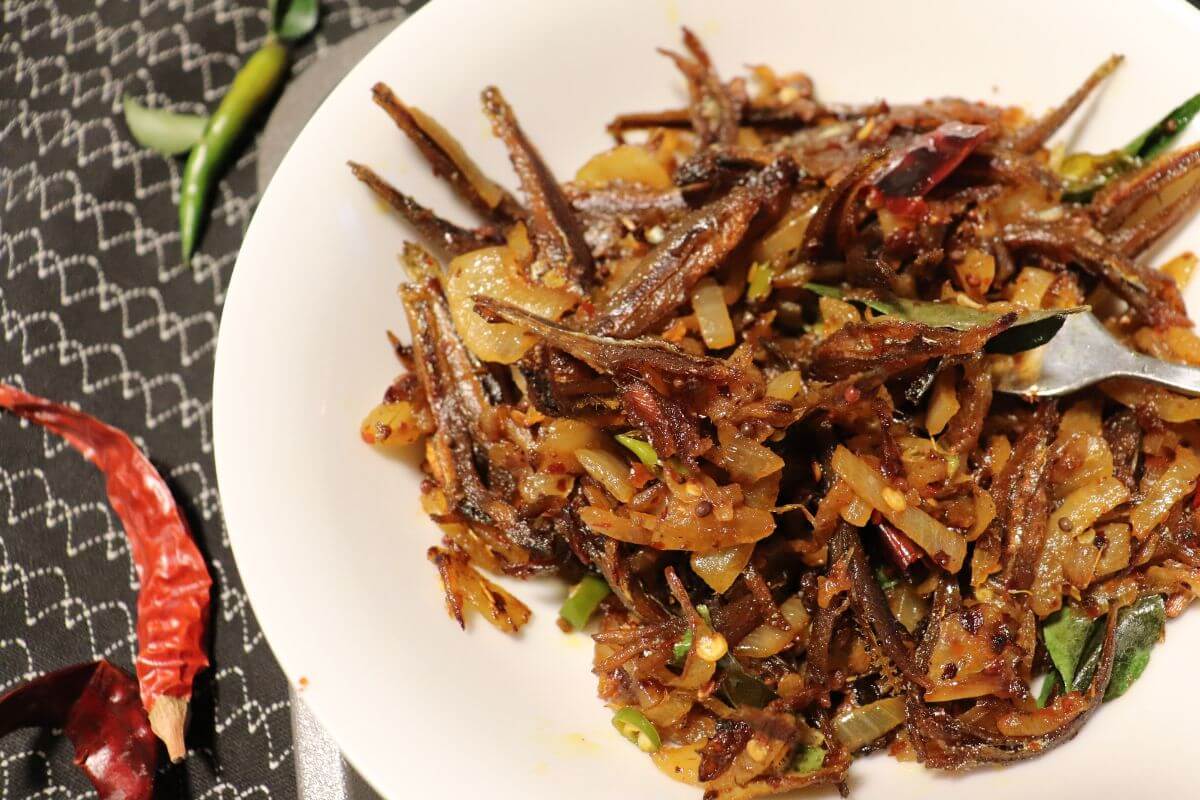 Sri Lankan anchovies sambal served in a bowl with crispy fried anchovies and chili flakes.