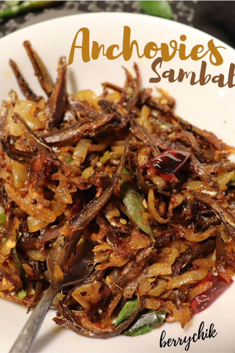Anchovies sambal being stir-fried with onions, garlic, curry leaves, and spices.