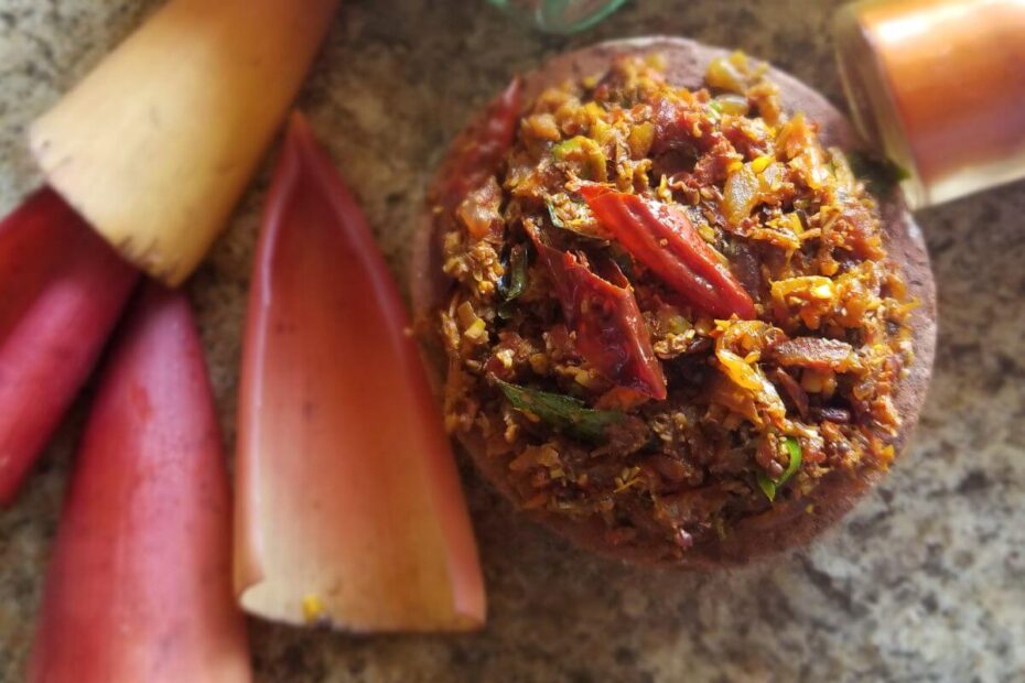 Banana flower being stir-fried with onions, garlic, tomatoes, and spices in a pan.