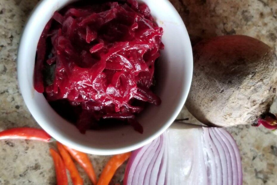 Close‑up of beetroot curry with sliced beets, onions, and tomatoes.