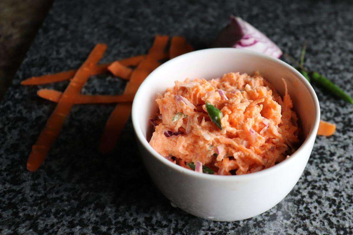Carrot sambal garnished with chilies and shallots in a bowl.