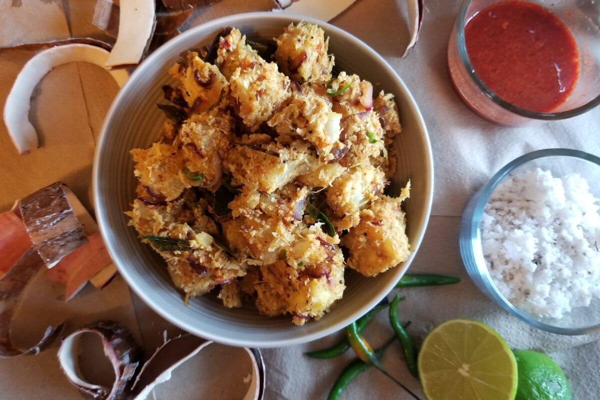 Cassava coconut stir‑fry plated with toasted spices and coconut flakes.