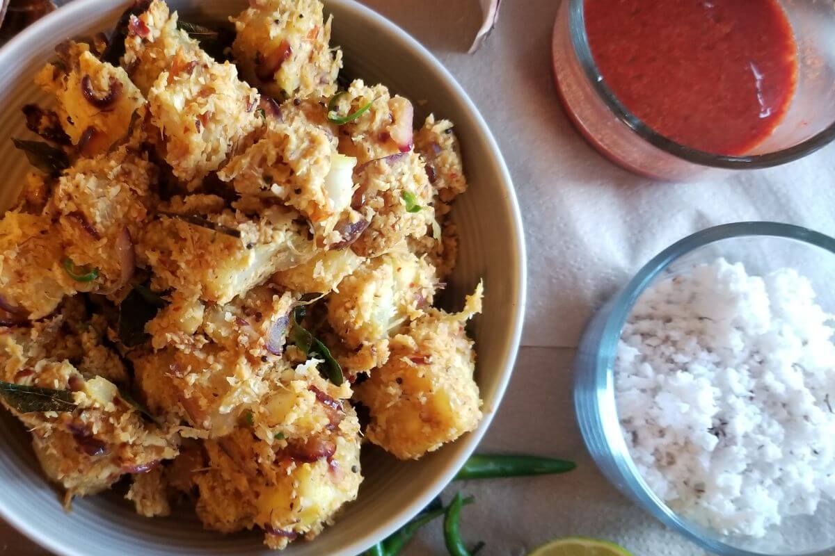 Close-up of cassava coconut stir‑fry with visible chilies and coconut flakes.