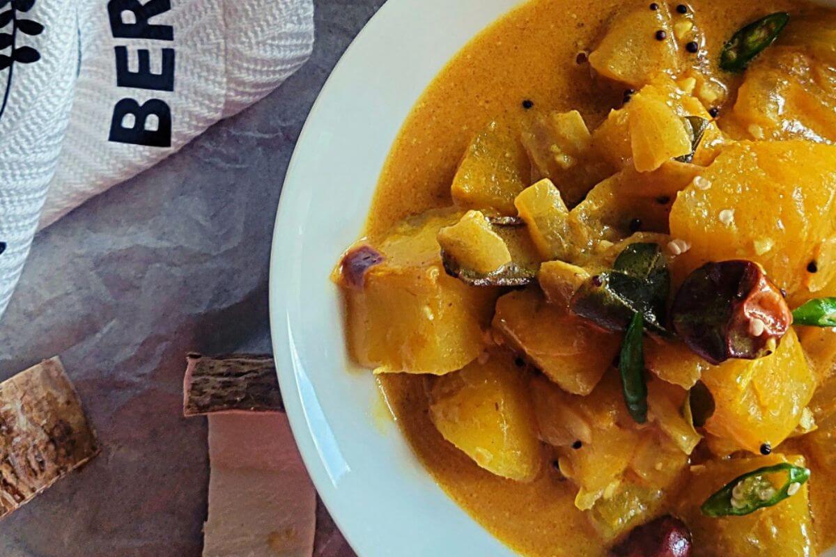 Close-up of cassava curry showing tender cassava chunks and thick coconut gravy.