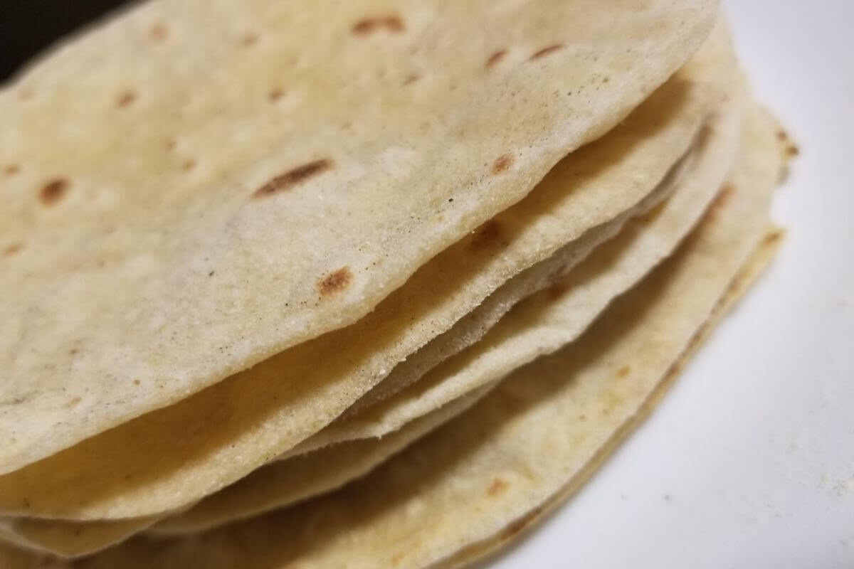 side view of homemade chapati arranged neatly on a serving plate.