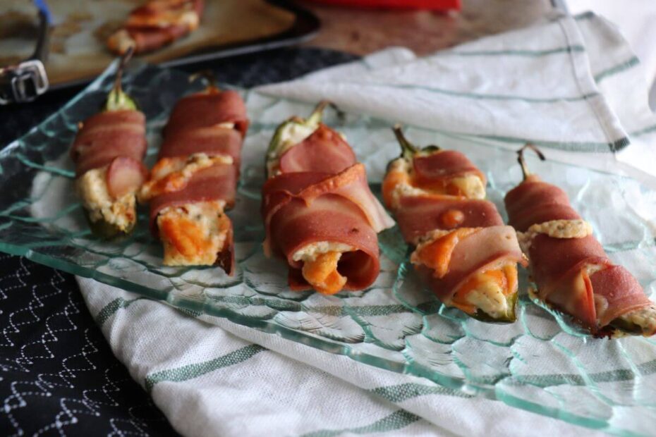 Freshly baked chicken‑wrapped jalapeño poppers with melted cheese, served in a bowl.