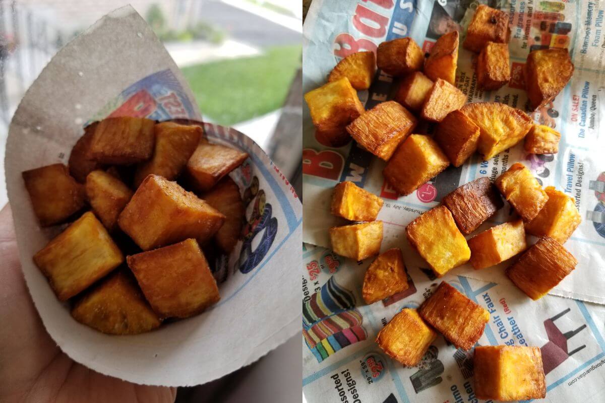 Golden deep fried cassava chunks served in a bowl with salt and chili powder.