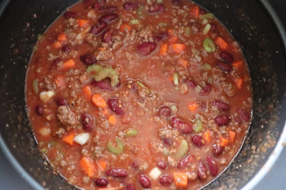 Overhead view of pressure cooker chili in a bowl with toppings.