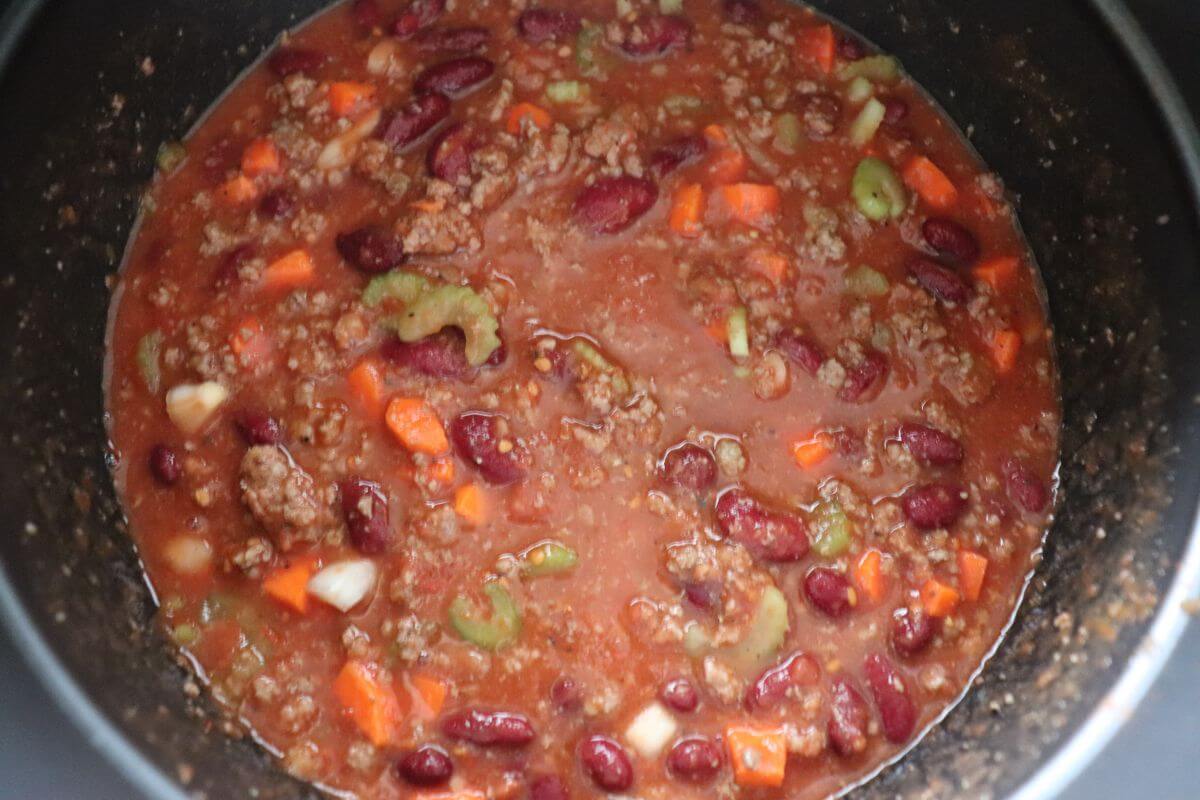 Overhead view of pressure cooker chili in a bowl with toppings.