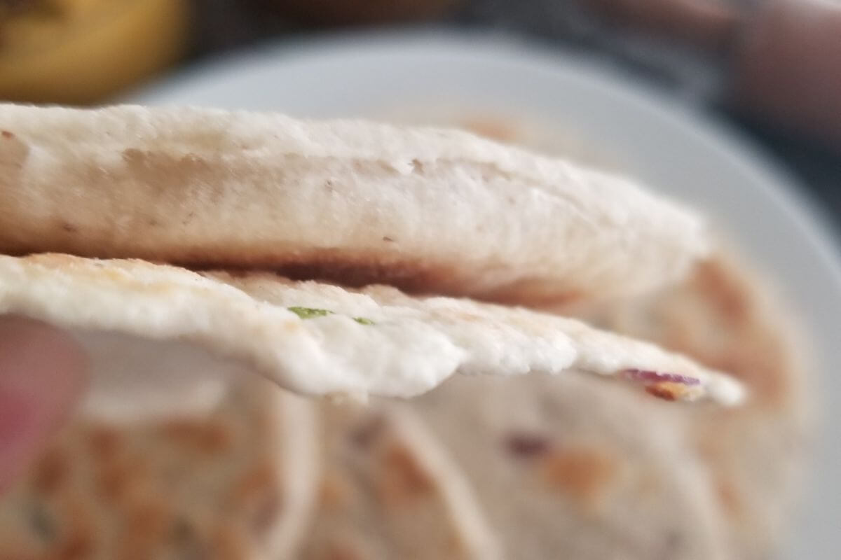 Side view of pol roti showing a close up of the thin coconut roti texture.