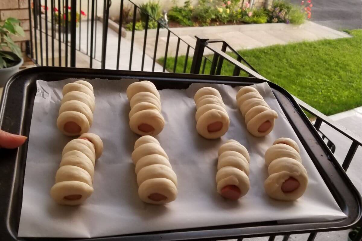 Side view of hotdog buns showing the soft dough and exposed sausage ends.
