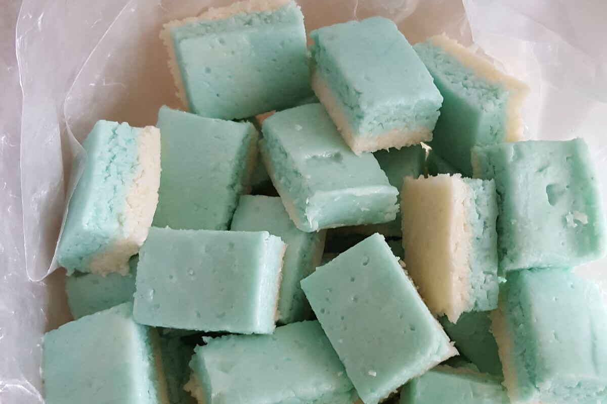 handful of vegan coconut ice treats piled on a counter