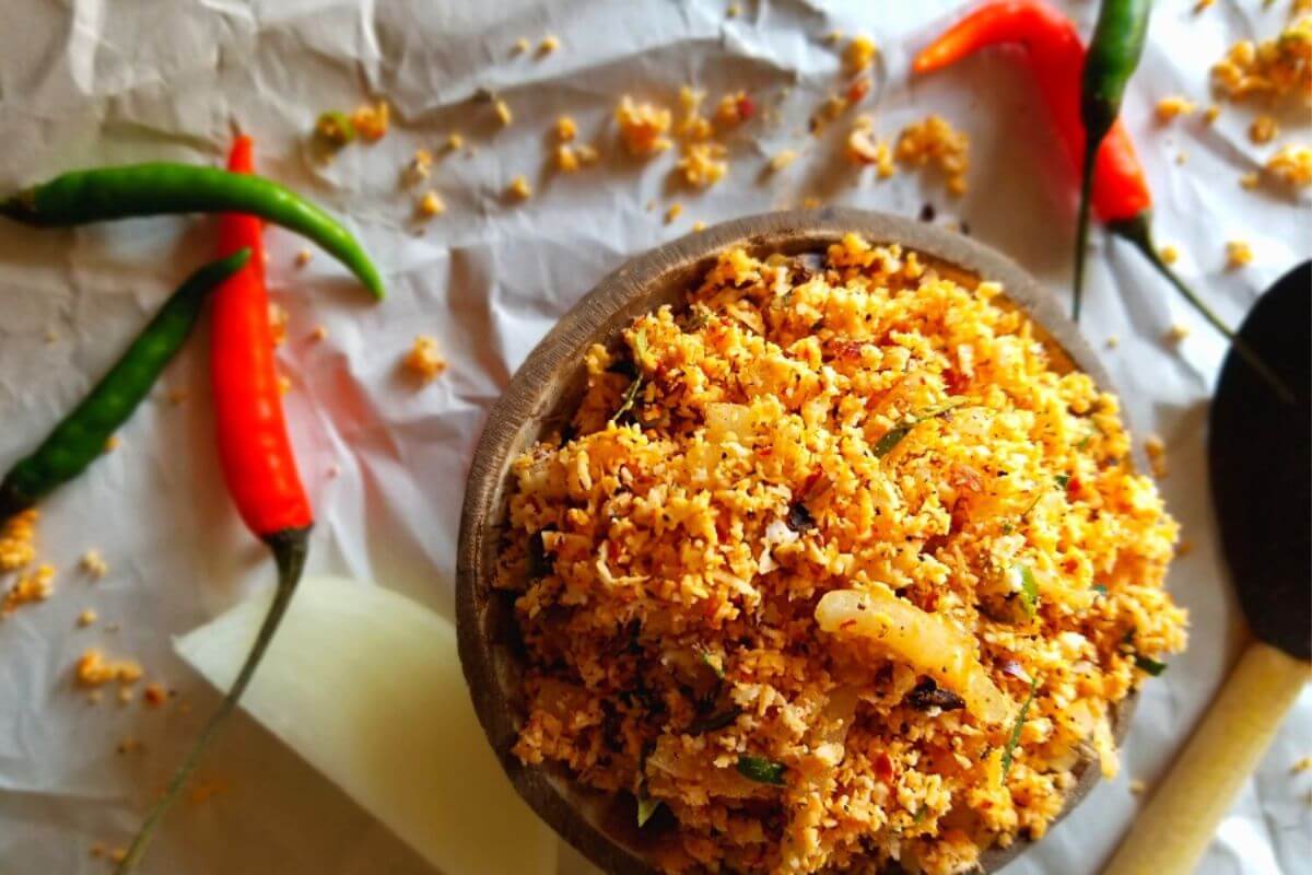 Fresh Sri Lankan coconut sambal in a bowl with bright red chili, onions, and grated coconut.