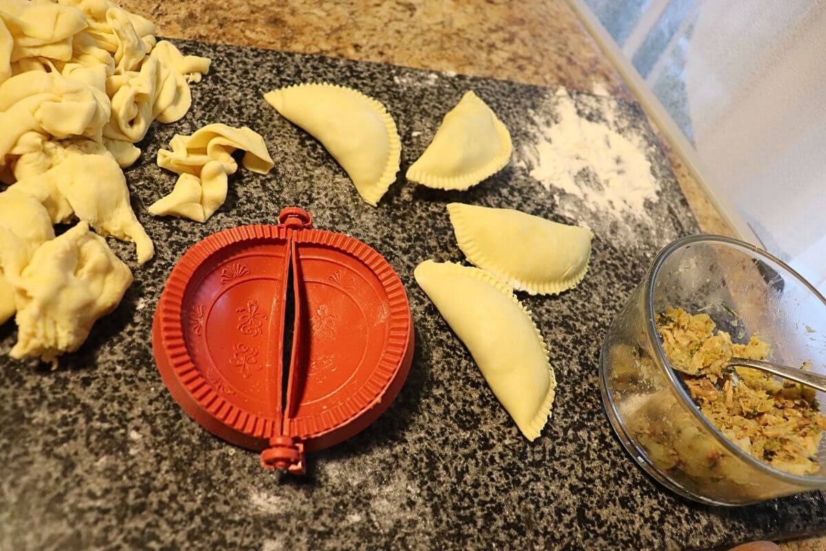 fish sambal, the dough, and the mold is all placed on table to make the sri lankan fish patties