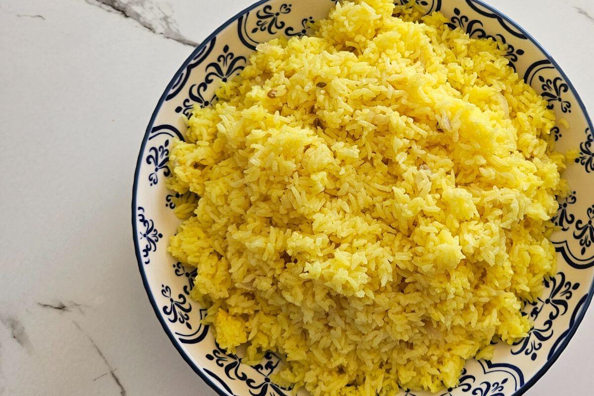 Sri Lankan yellow ghee rice made just like the locals do and presented on a plate ready to garnish