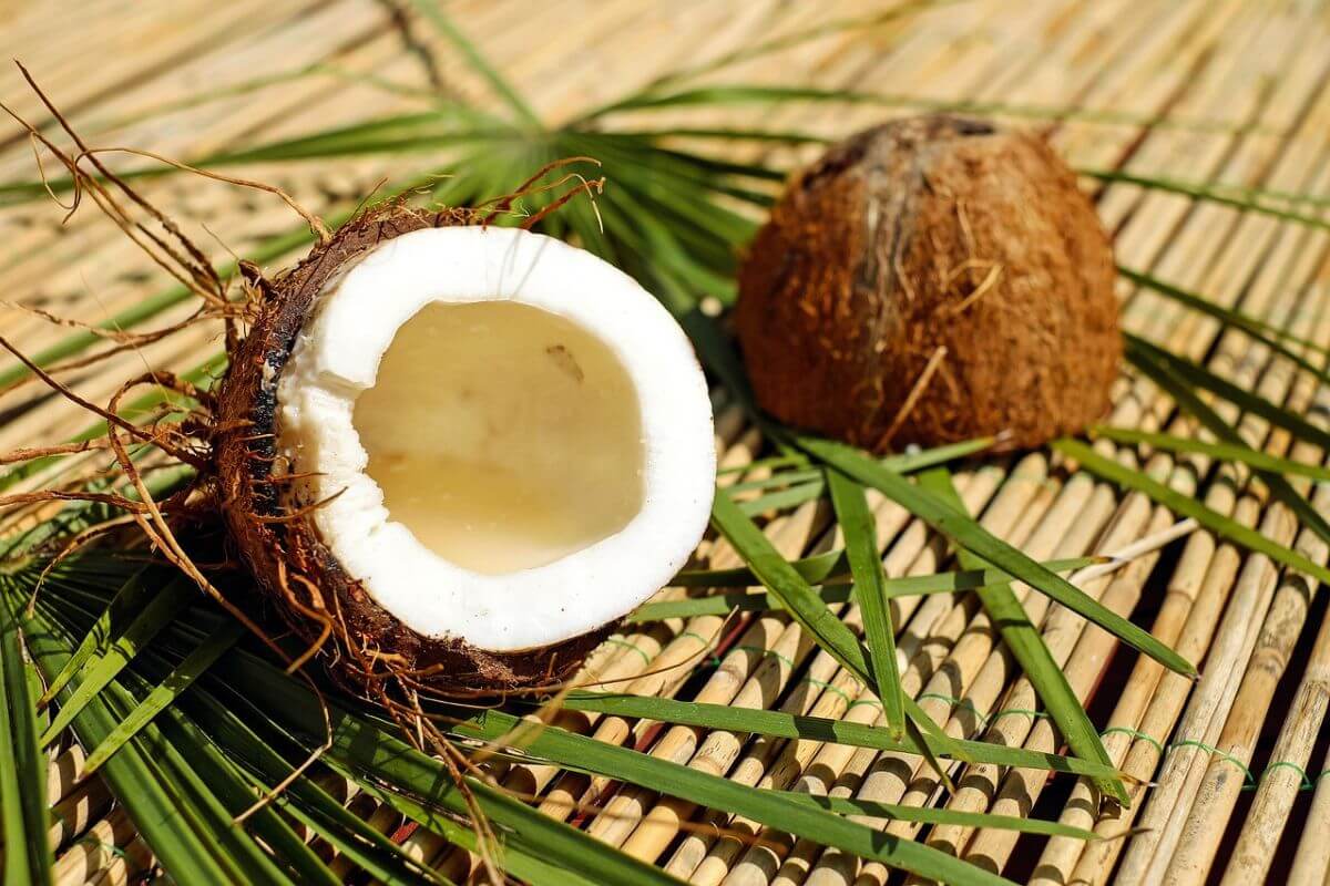 Two coconut halves showing the white flesh inside, freshly cracked and ready for cooking.