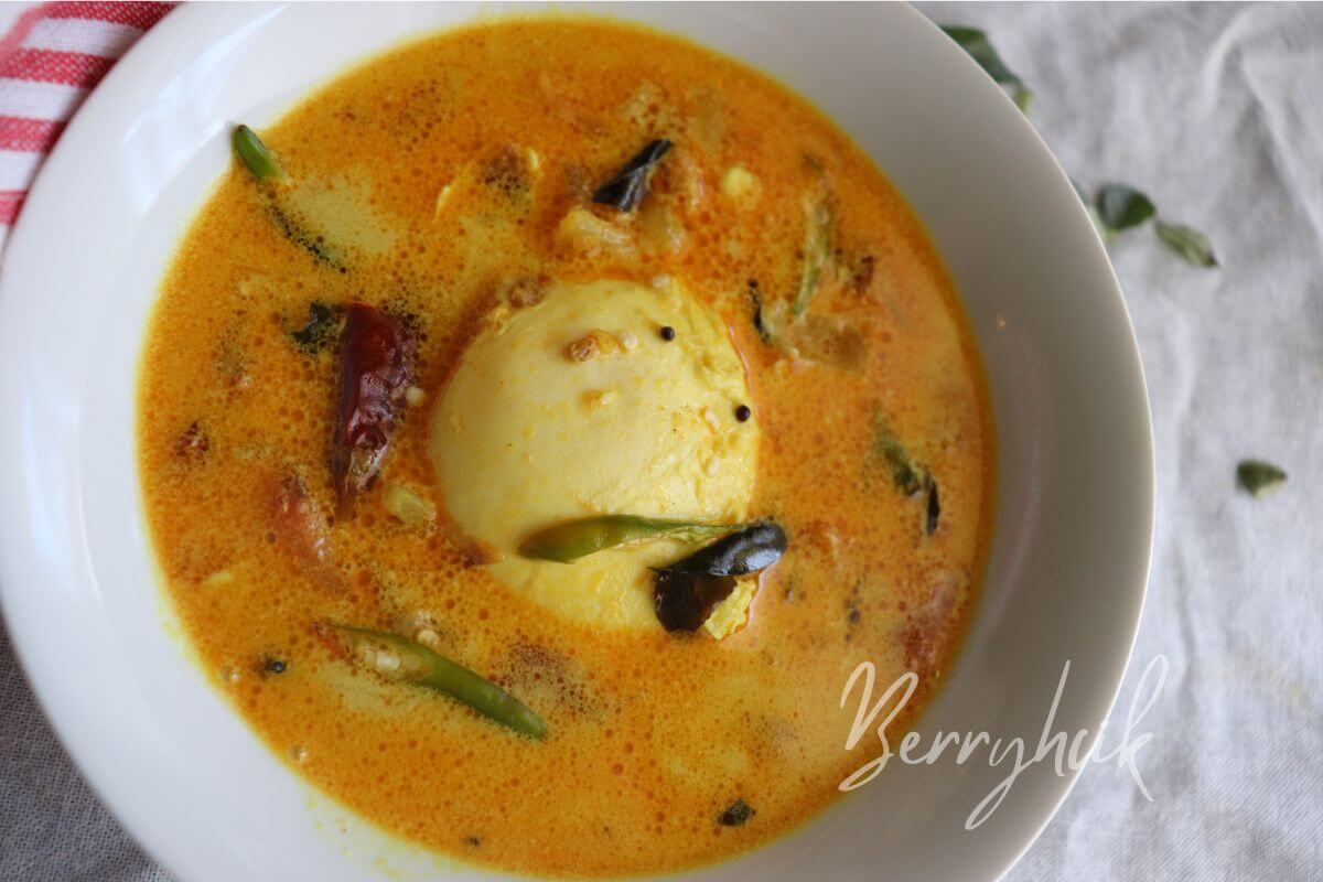 Close‑up of a poached egg sitting in a turmeric‑spiced Sri Lankan coconut curry, simple one‑pot egg curry for busy households.