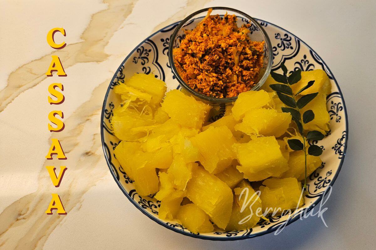 Close-up bowl of boiled cassava with fresh coconut sambal on the side.