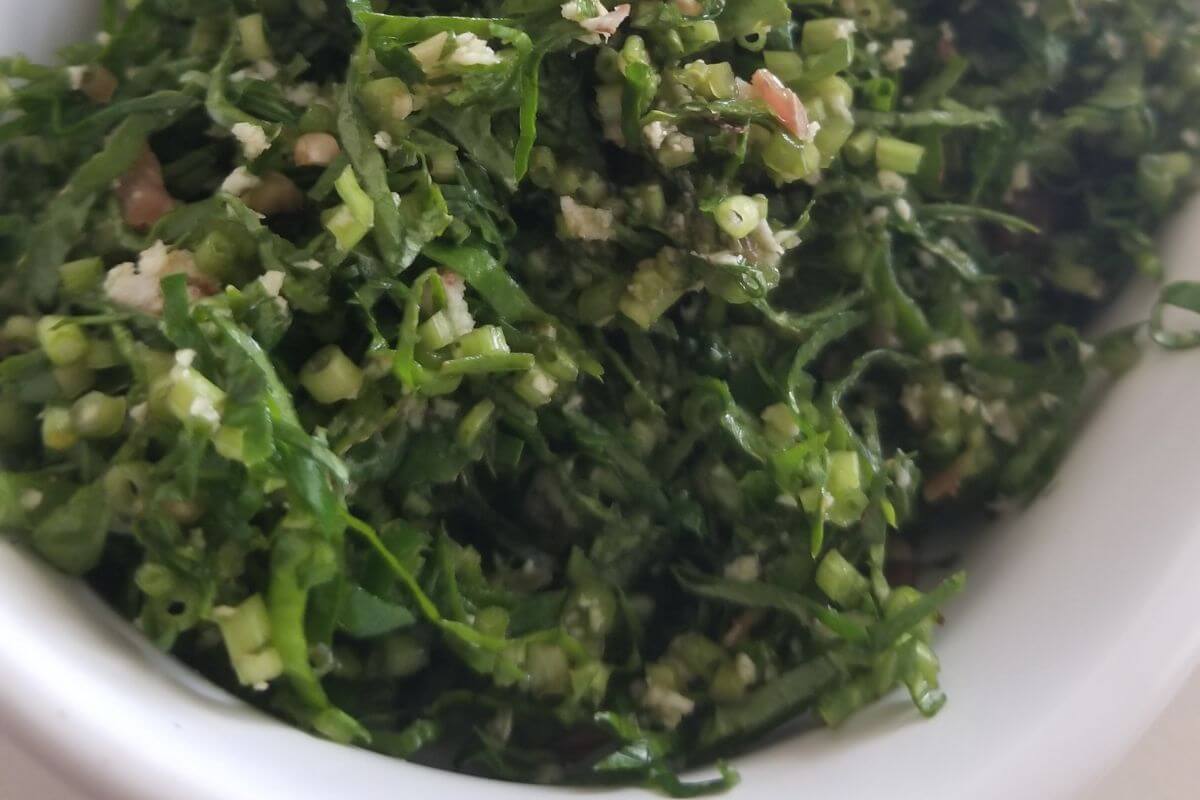 Close‑up of finely sliced gotu kola sambol mixed with coconut and green chilies, traditional Sri Lankan supergreen side dish.