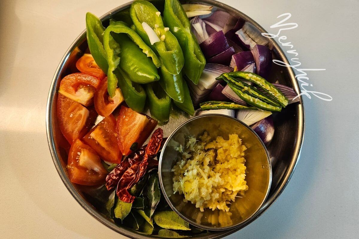 Bowl of chopped onions, tomatoes, green chilies, garlic, and peppers prepared for Sri Lankan deviled fish.