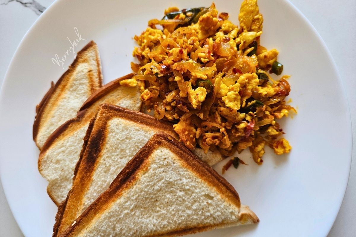 Plate of Sri Lankan scrambled egg sambal served with three slices of golden toast.