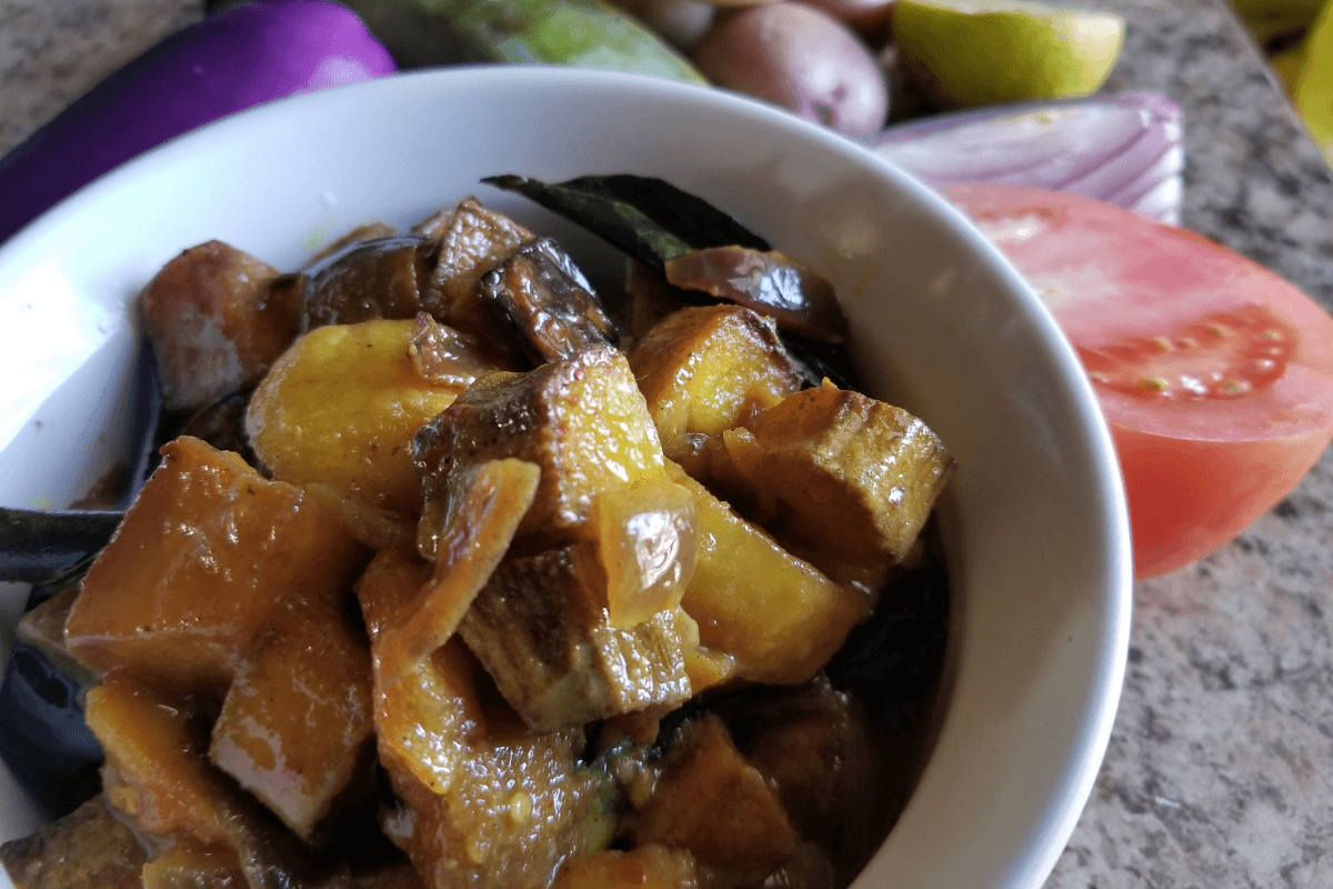 Cubed eggplant, plantain, and potato seasoned with turmeric and salt, ready to be air‑fried for Sri Lankan curry.