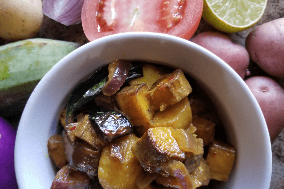 veggies, herbs, and spice mixed in a bowl for Sri Lankan eggplant curry.
